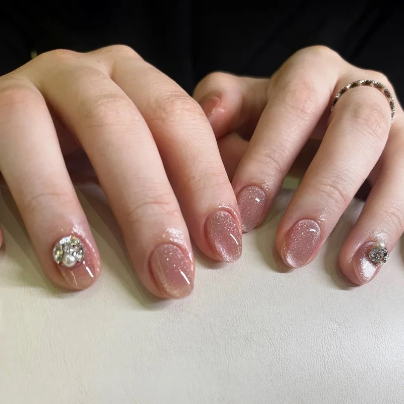 Kunstvolle Glitzer-Nagelverlängerungen mit eleganten Strass-Akzenten Karnz