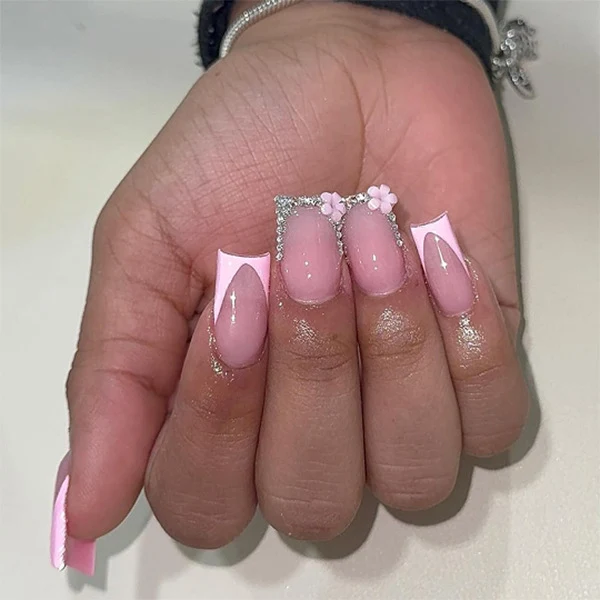 Kunstvolle Gel-Nägel mit eleganten floralem Design und Glitzerakzenten Karnz