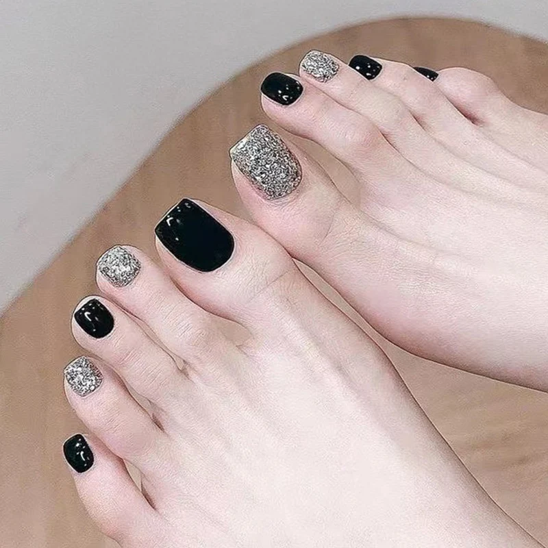 Kunstvolle Fußnagelkunst mit Glitzer- und Schwarzdesign Karnz