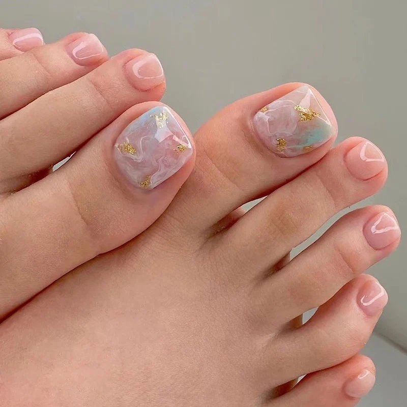 Kunstvolle Fußnagelkunst mit eleganten Marmor- und Goldakzenten Karnz