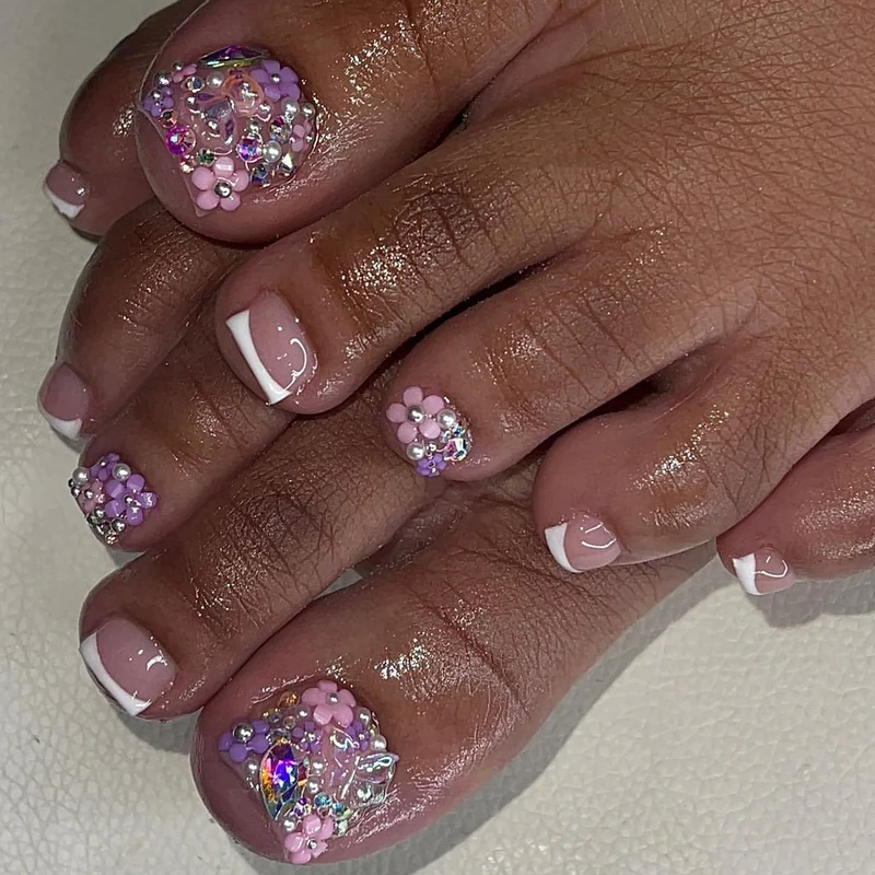 Kunstvolle Fußnagelkunst mit Blumenakzenten und Glitzer Karnz
