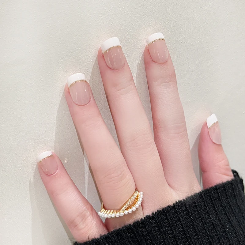 Kunstvolle Nagelverlängerungen mit elegantem French-Tip und Goldakzenten Karnz