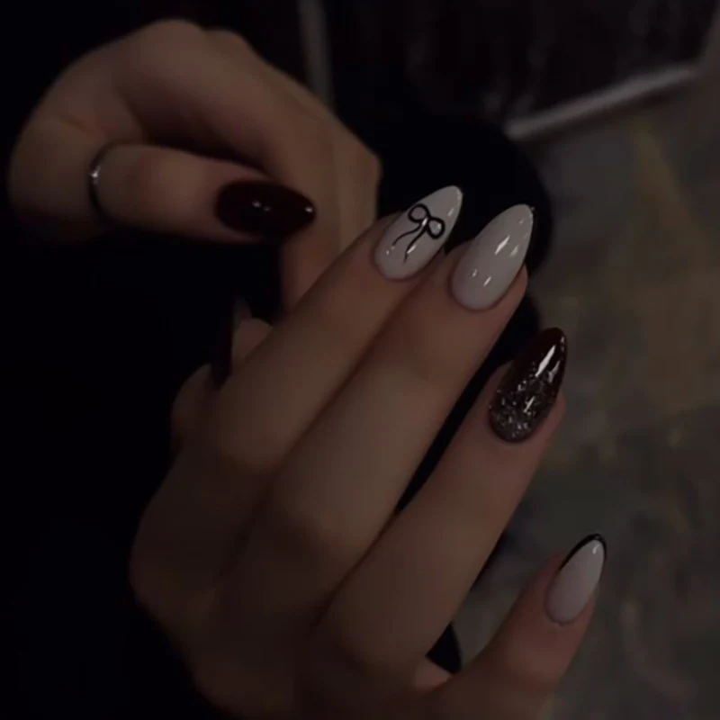 Kunstvolle Nagelkunst mit elegantem Schleifenmuster und Glitzer akzenten Karnz