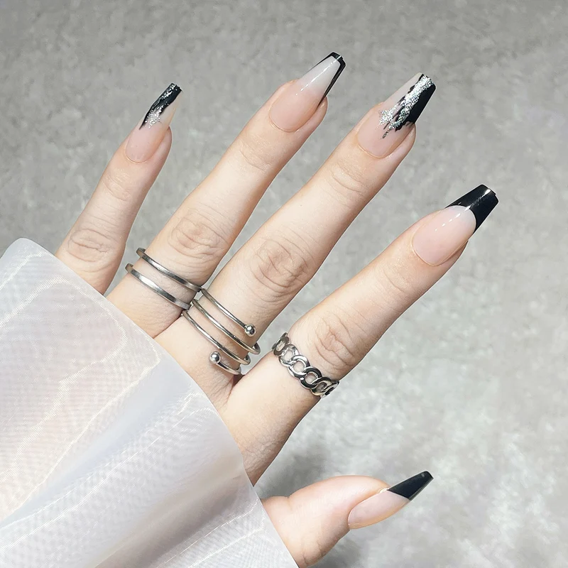 Elegante Stiletto Press-On Nägel mit künstlerischen schwarzen Spitzen und silbernen Akzenten Karnz