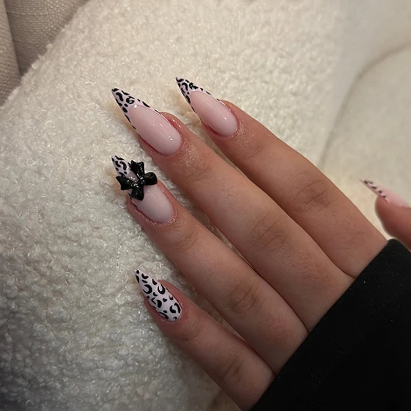 Kunstvolle Stiletto-Nägel mit Leopardenmuster und Schleifenakzent Karnz