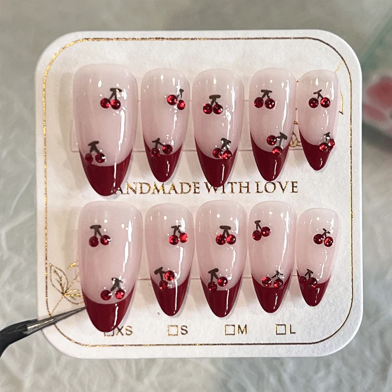 Kunstvolle Stiletto-Nägel mit Kirschmotiven und Glitzerakzenten Karnz