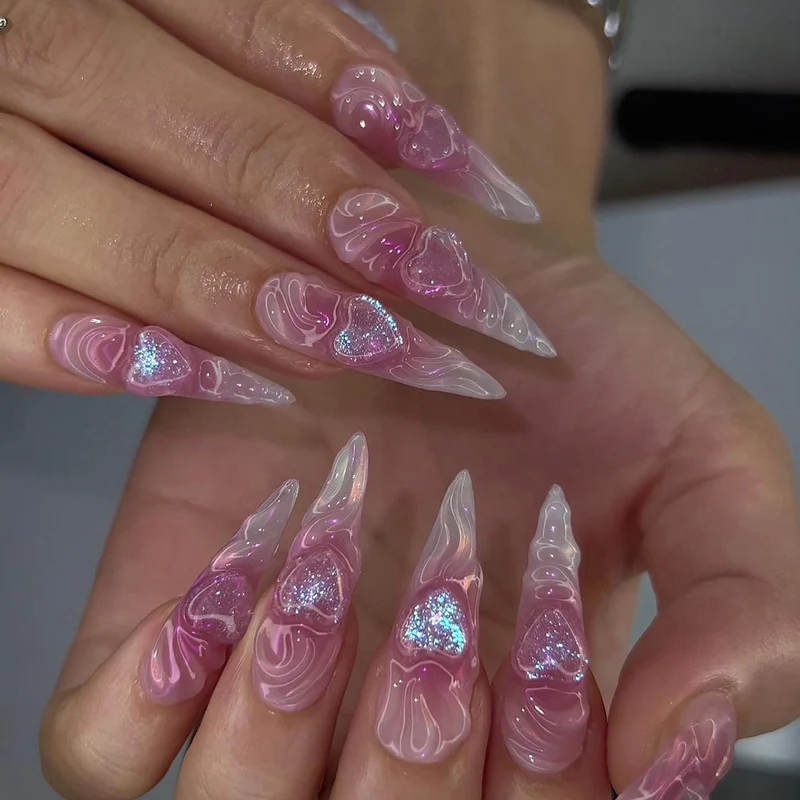 Kunstvolle Stiletto-Nägel mit Herz-Design und Glitzerakzenten Karnz