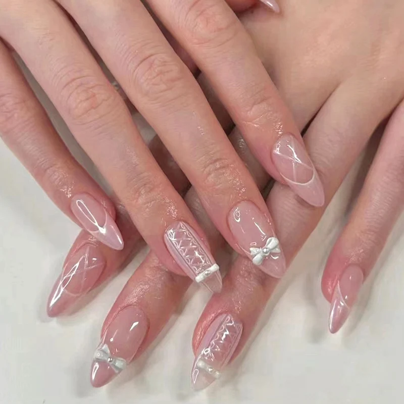 Kunstvolle Stiletto-Nägel mit eleganten Perlen- und Schleifenakzenten Karnz