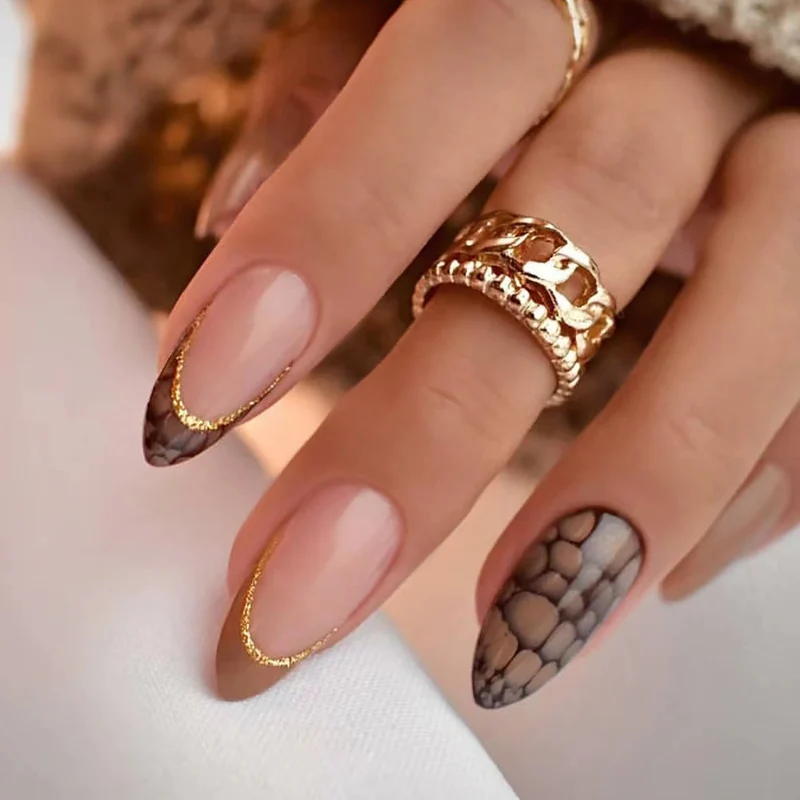 Kunstvolle Stiletto-Nägel mit elegantem Goldverzierung Karnz