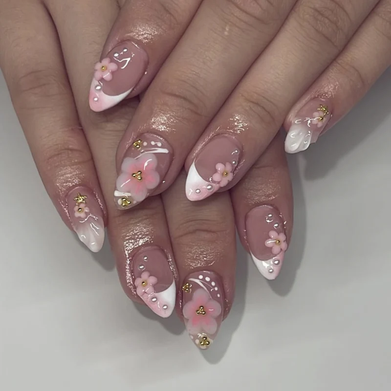 Kunstvolle Nagelverlängerungen mit Blütenmuster und Glitzerakzenten Karnz
