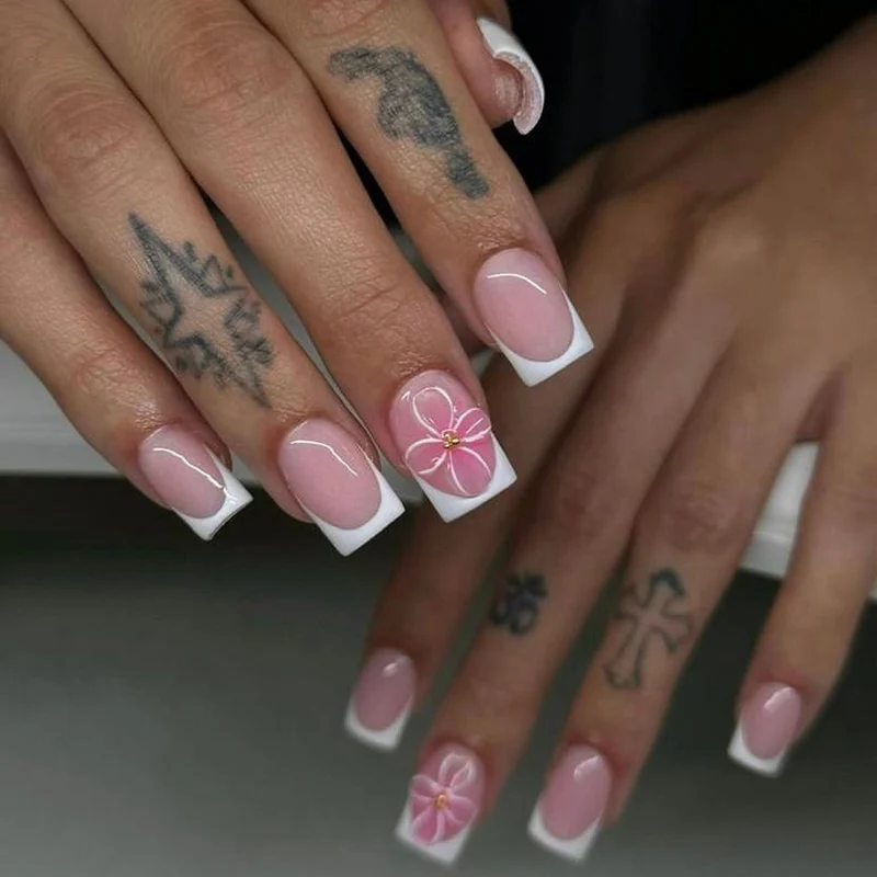 Kunstvolle Nagelkunst mit zarten Blüten und eleganter French-Spitze Karnz
