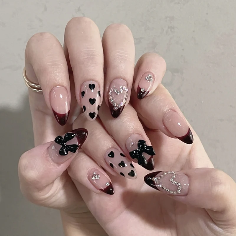 Künstlerische Stiletto-Nagelverlängerungen mit Herz- und Schleifenakzenten Karnz