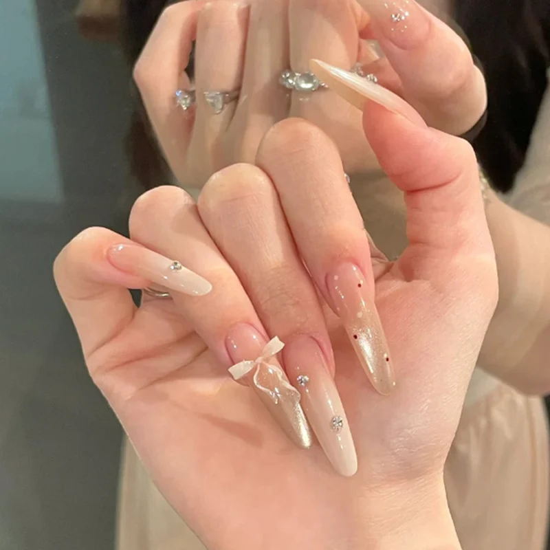 Elegante Stiletto Press-On Nägel mit dekorativem Bogen und Strassakzenten Karnz