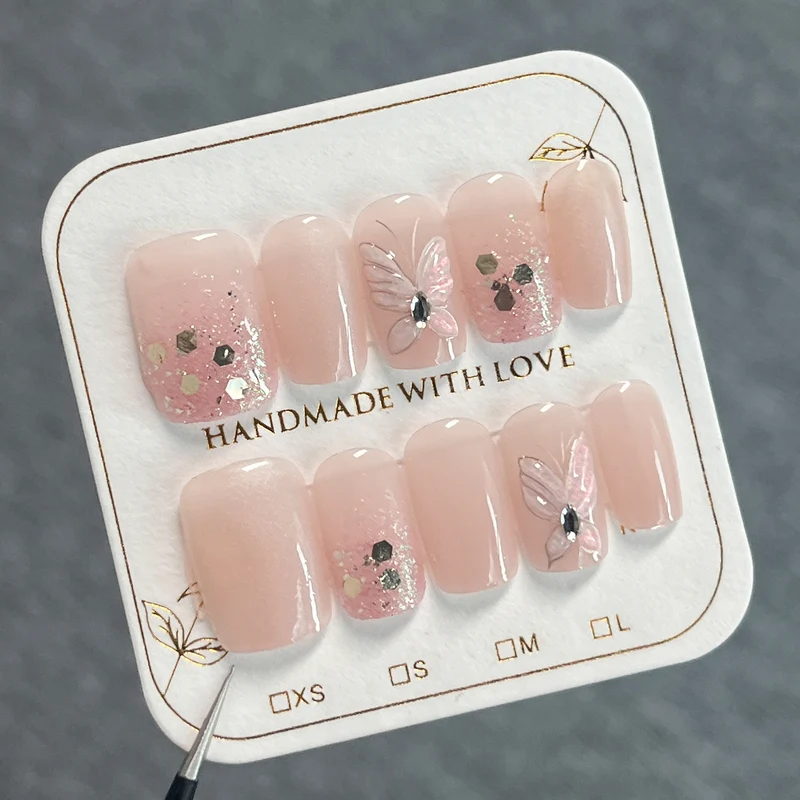 Kunstvolle Nagelkunst mit Schmetterlingsmotiven und Glitzerakzenten Karnz