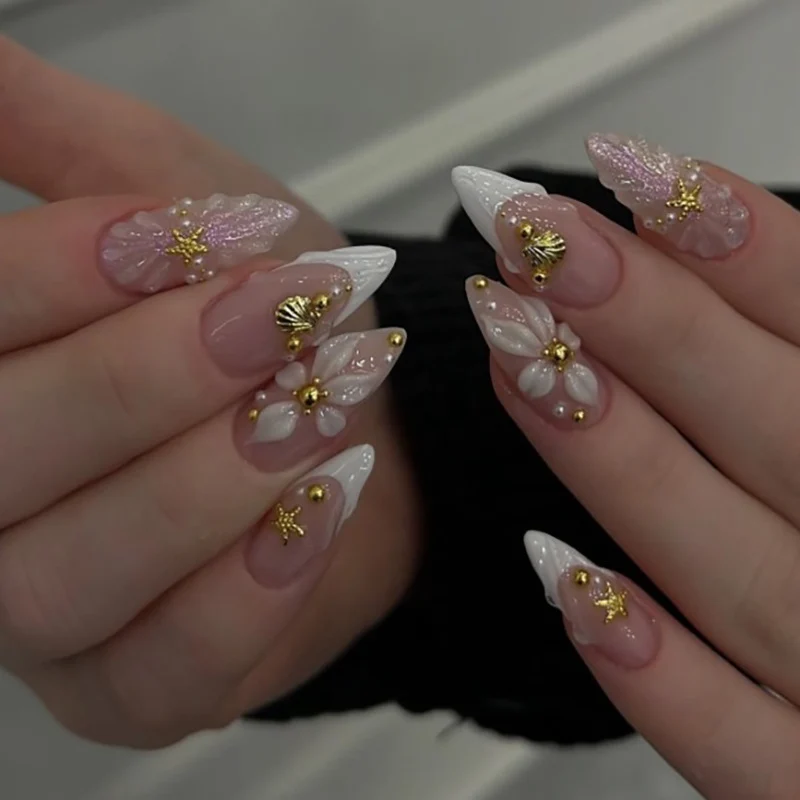 Kunstvolle Nagelkunst mit Muschel- und Blütenakzenten Karnz