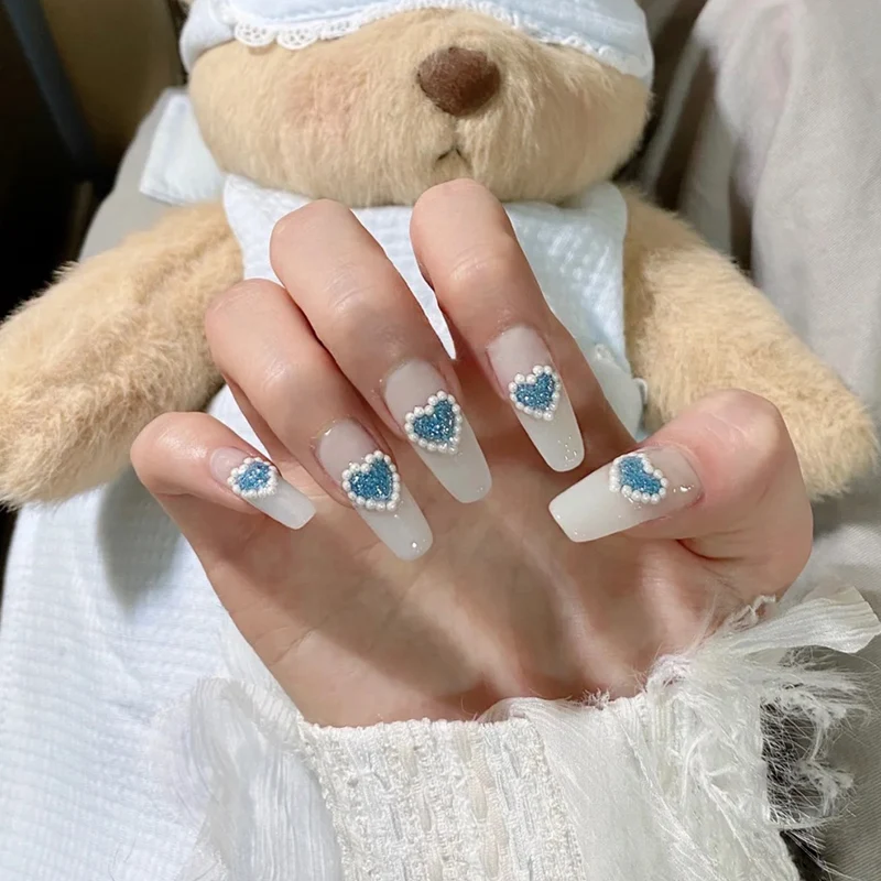 Kunstvolle Nagelkunst mit herzförmigen Akzenten Karnz