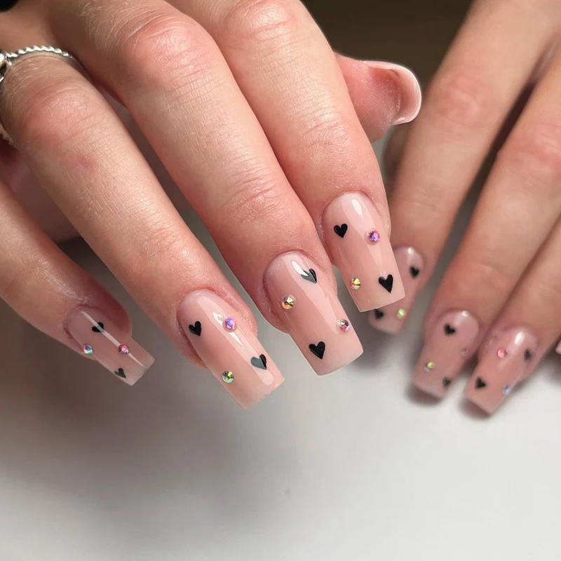 Kunstvolle Nagelkunst mit Herz-Design und Glitzerakzenten Karnz