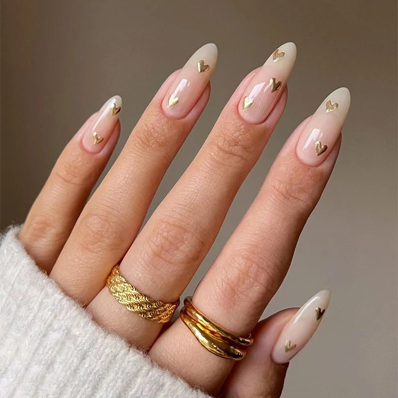 Kunstvolle Nagelkunst mit goldenen Herzakzenten Karnz