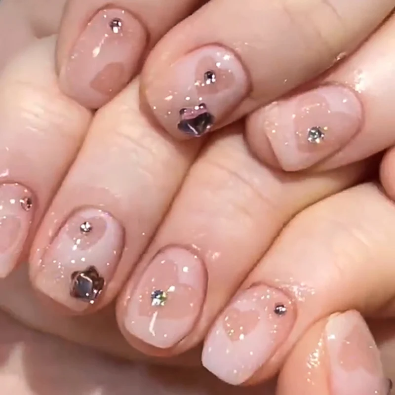 Kunstvolle Nagelkunst mit Glitzer- und Herzmotiven Karnz