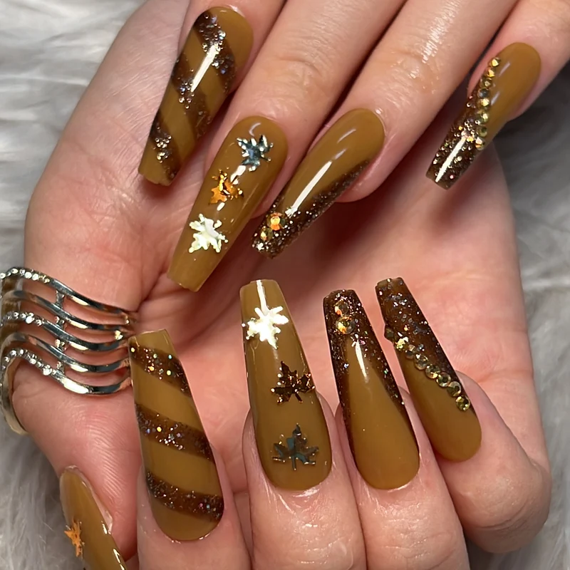 Kunstvolle Nagelkunst mit Glitter- und Blätterdesign Karnz
