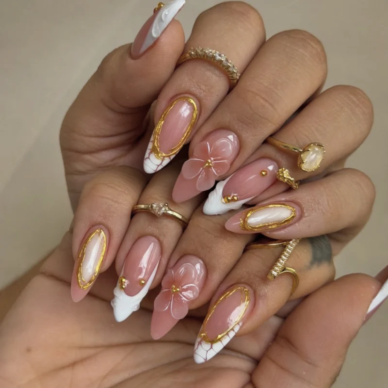 Kunstvolle Nagelkunst mit floralen und goldenen Akzenten Karnz