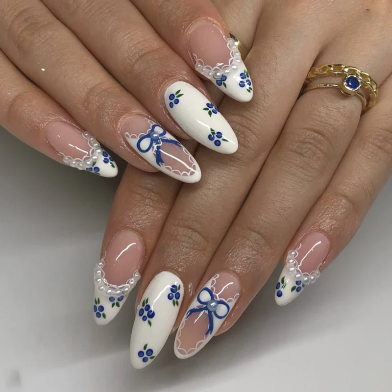 Kunstvolle Nagelkunst mit floralen Akzenten und Schleifenverzierung Karnz