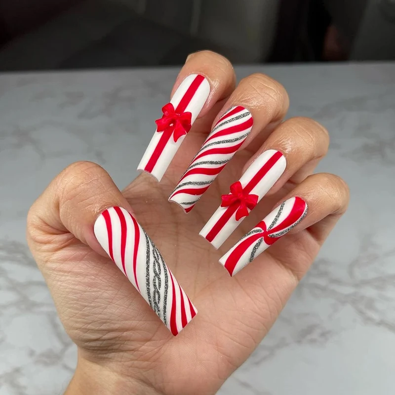 Kunstvolle Nagelkunst mit festlichen Schleifen und Weihnachtsmotiven Karnz