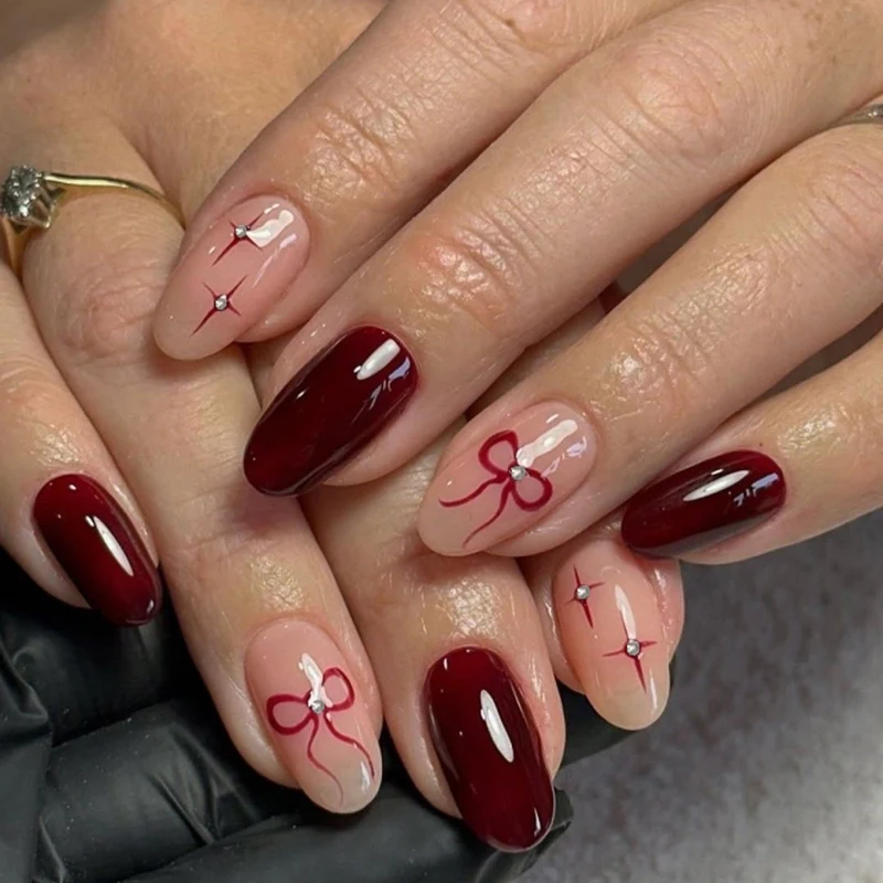 Kunstvolle Nagelkunst mit eleganten Schleifen und Strassverzierungen Karnz