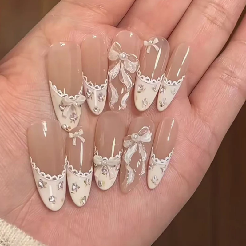 Kunstvolle Nagelkunst mit eleganten Schleifen und Strass-Details Karnz
