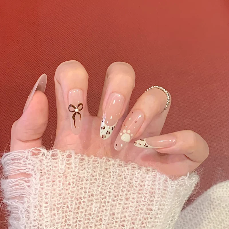 Dekorative Press-On Nagelkunst mit Schleife und Tierakzenten Karnz