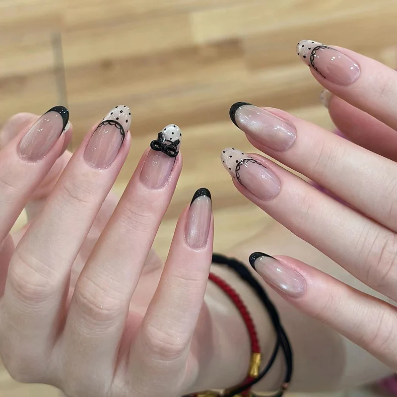 Künstlerisches Französisches Tipp-Nail Design mit Schleifenverzierungen Karnz