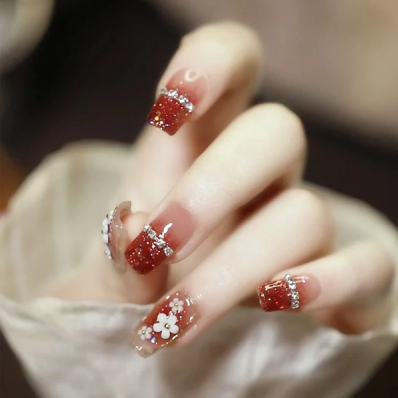 Künstlerische Press-On Nagelkunst mit floralen und Glitzerakzenten Karnz