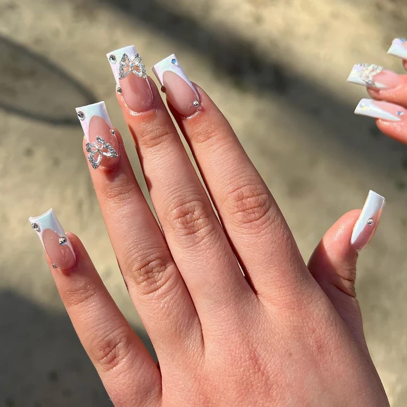 Elegante Nagelkunst mit Glitzer und floralen Akzenten Karnz
