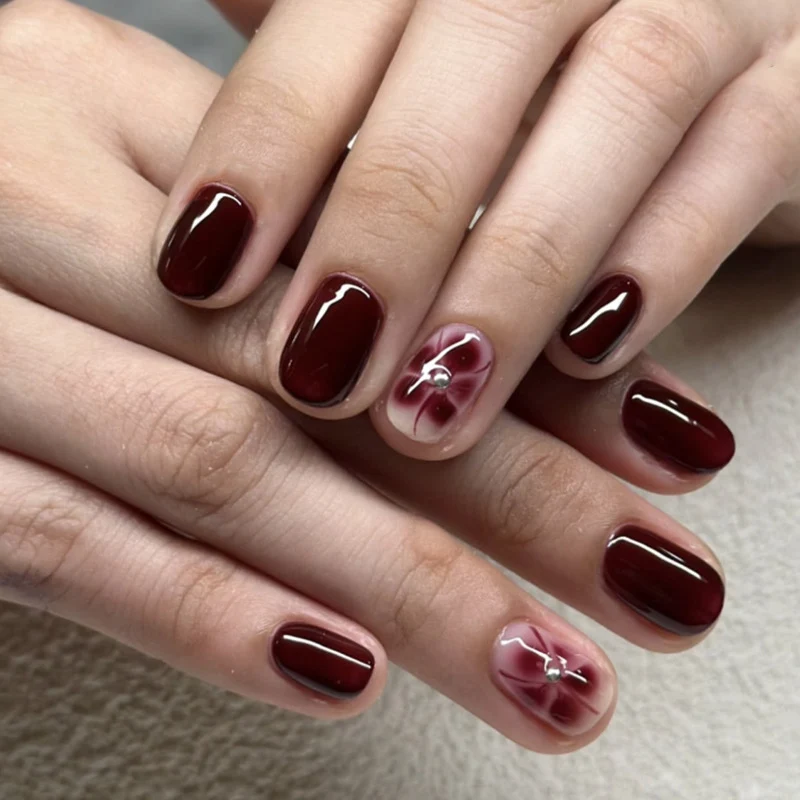 Elegante Nagelkunst mit Glitzer- und Blumenelementen Karnz