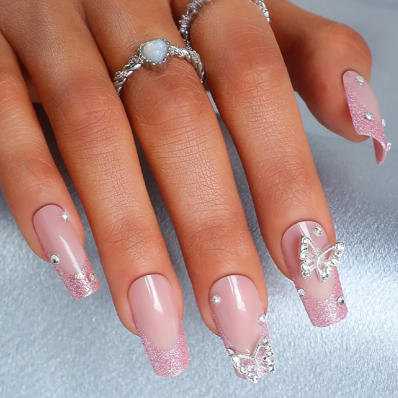 Kunstnagelset mit funkelnden Glitzerakzenten und eleganten Schmetterlingsmotiven Karnz