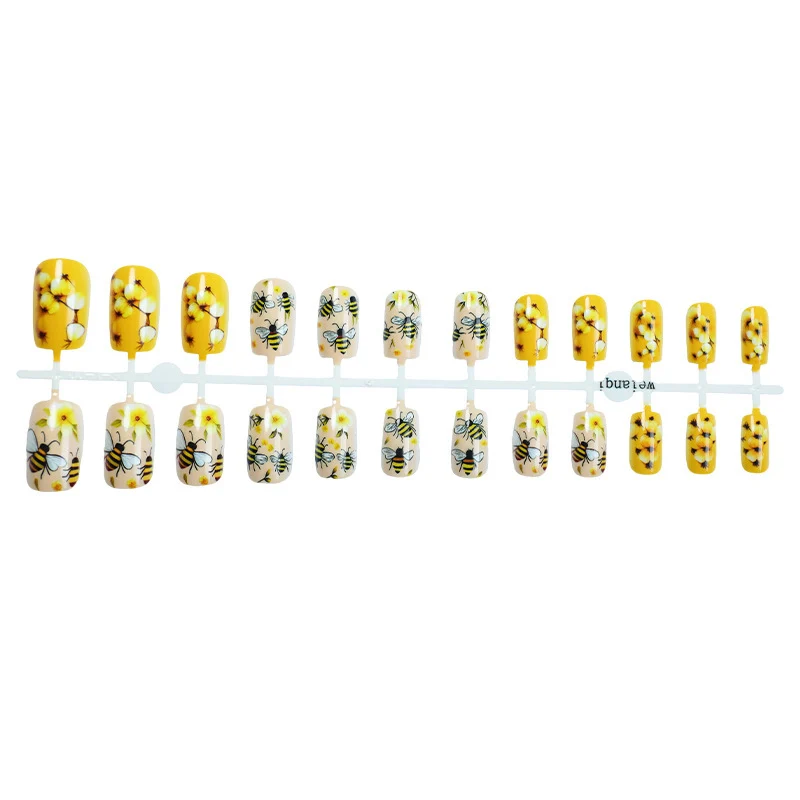 Kunstnagelset mit floralen und bienenmotiven Karnz
