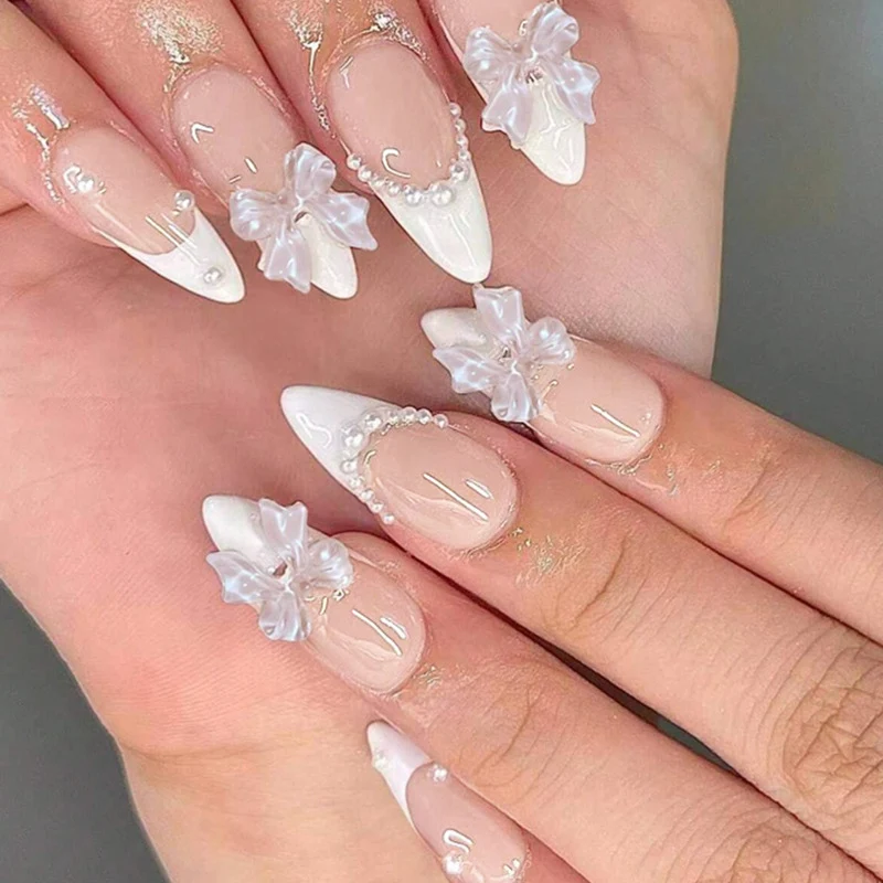 Kunstnagelset mit eleganten Schleifen und Perlverzierungen Karnz