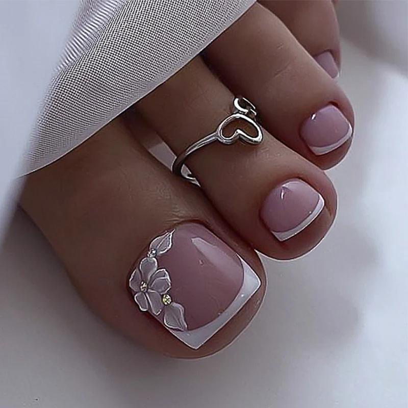 Kunstvolle Fußnagelgestaltung mit filigranen Blüten und Glitzerbesatz Karnz